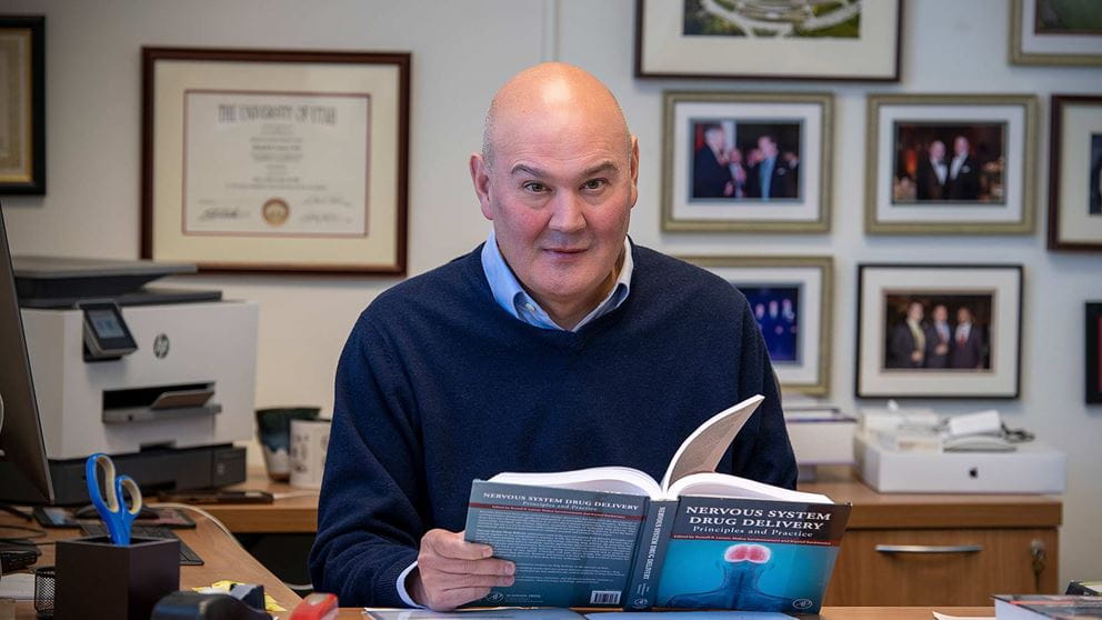 Dr. Lonser at his desk with a book in his hands