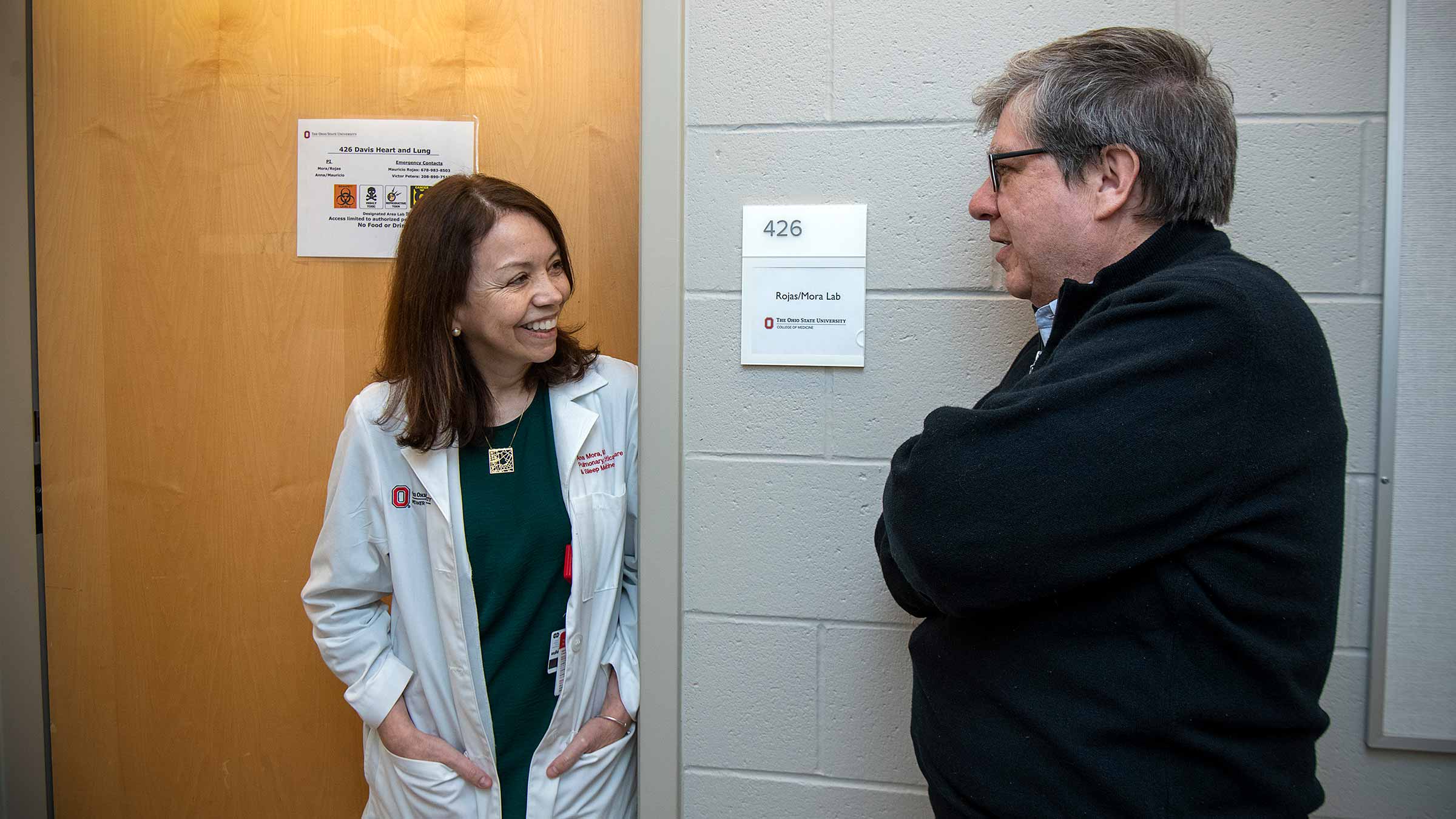 Ana Mora and Mauricio Rojas talking in a hallway