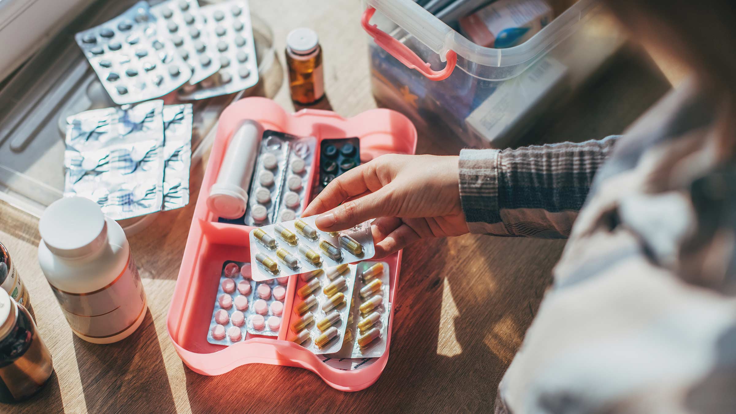 A woman organizing an emergency medicine supply box
