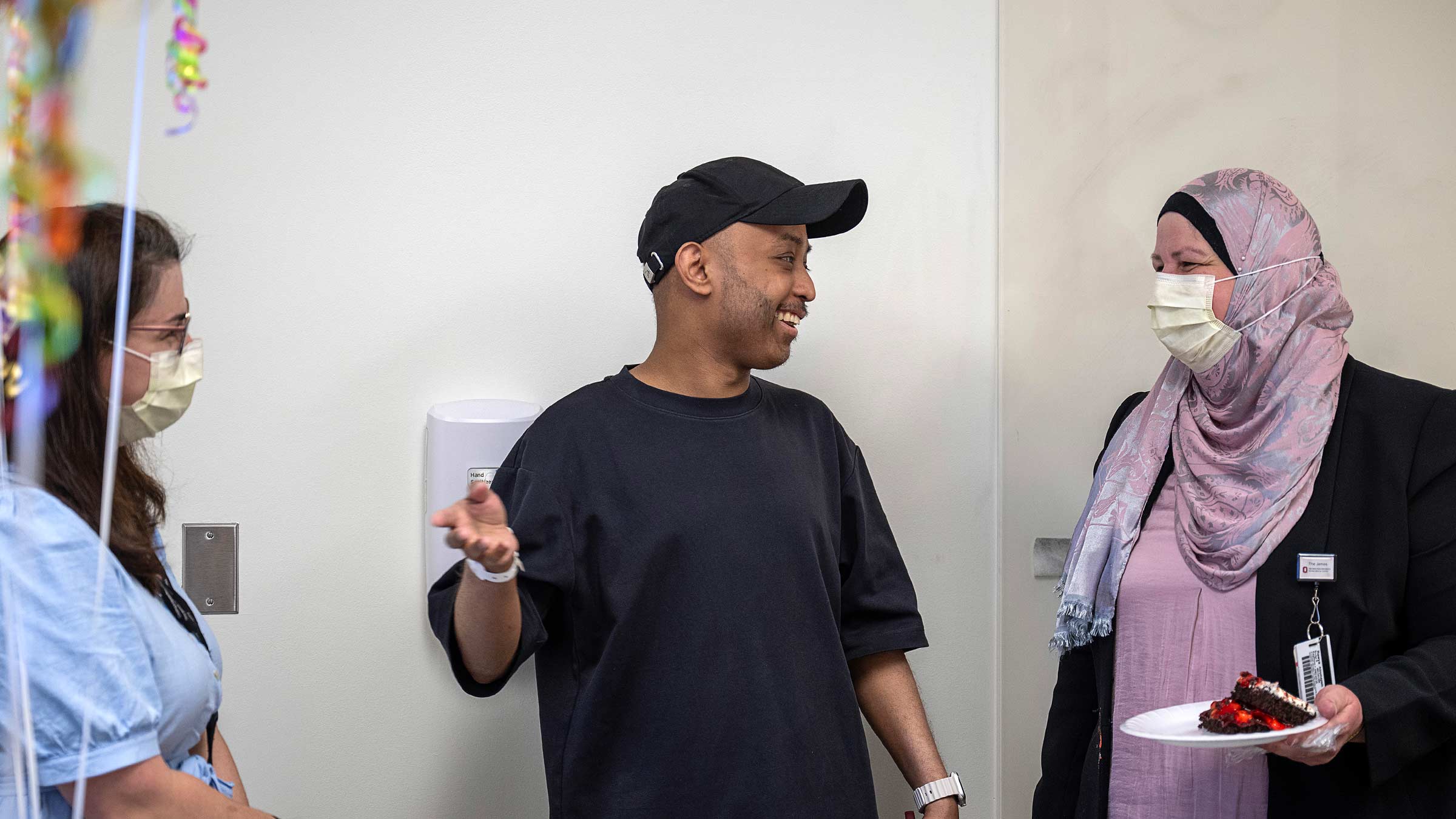 Sickle cell disease patient Khaled Alsheebani having cake with his doctors and family