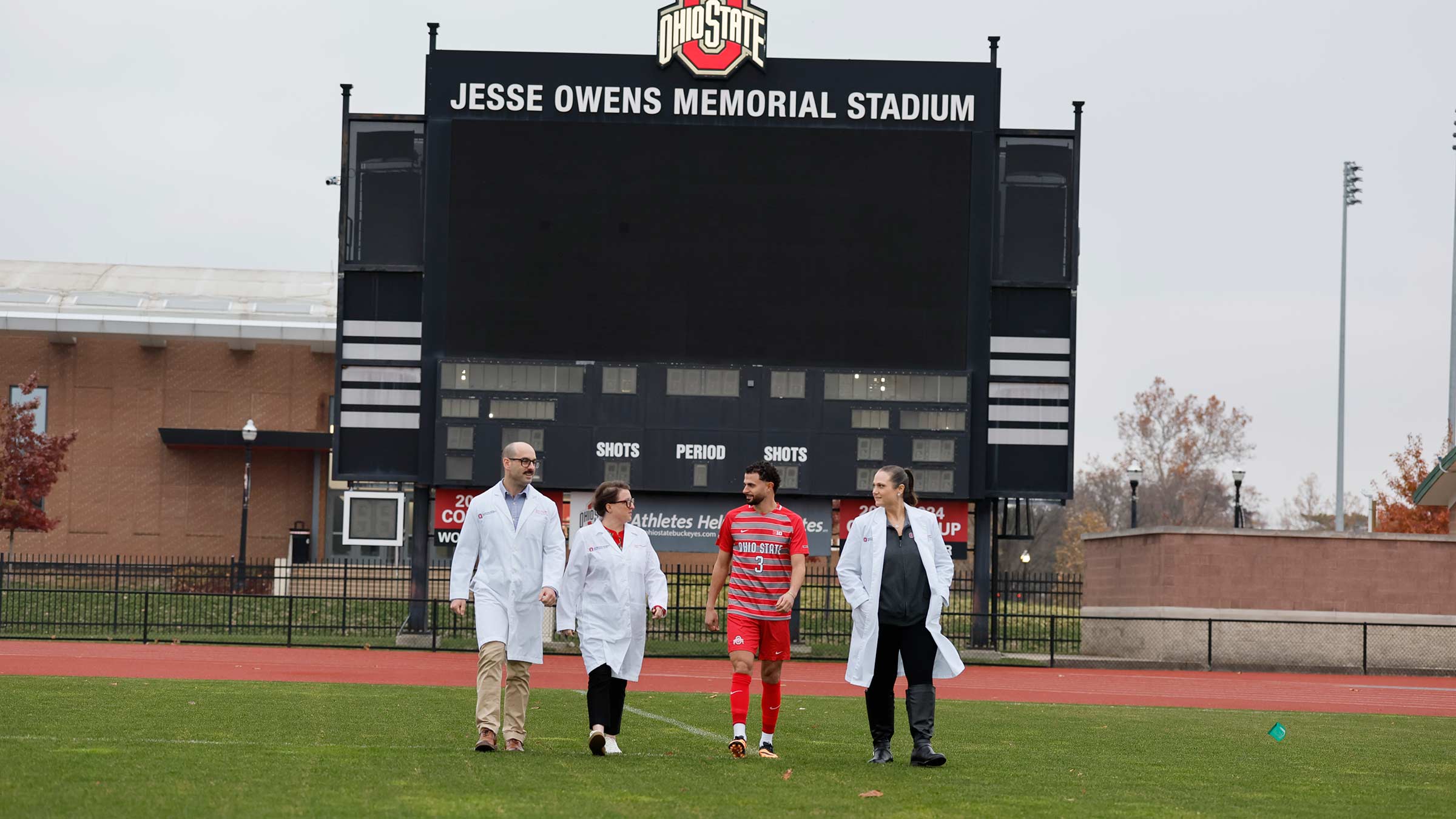 Nathan Demian and his trauma surgery team walking on the field in the Jesse Owens Memorial Stadium