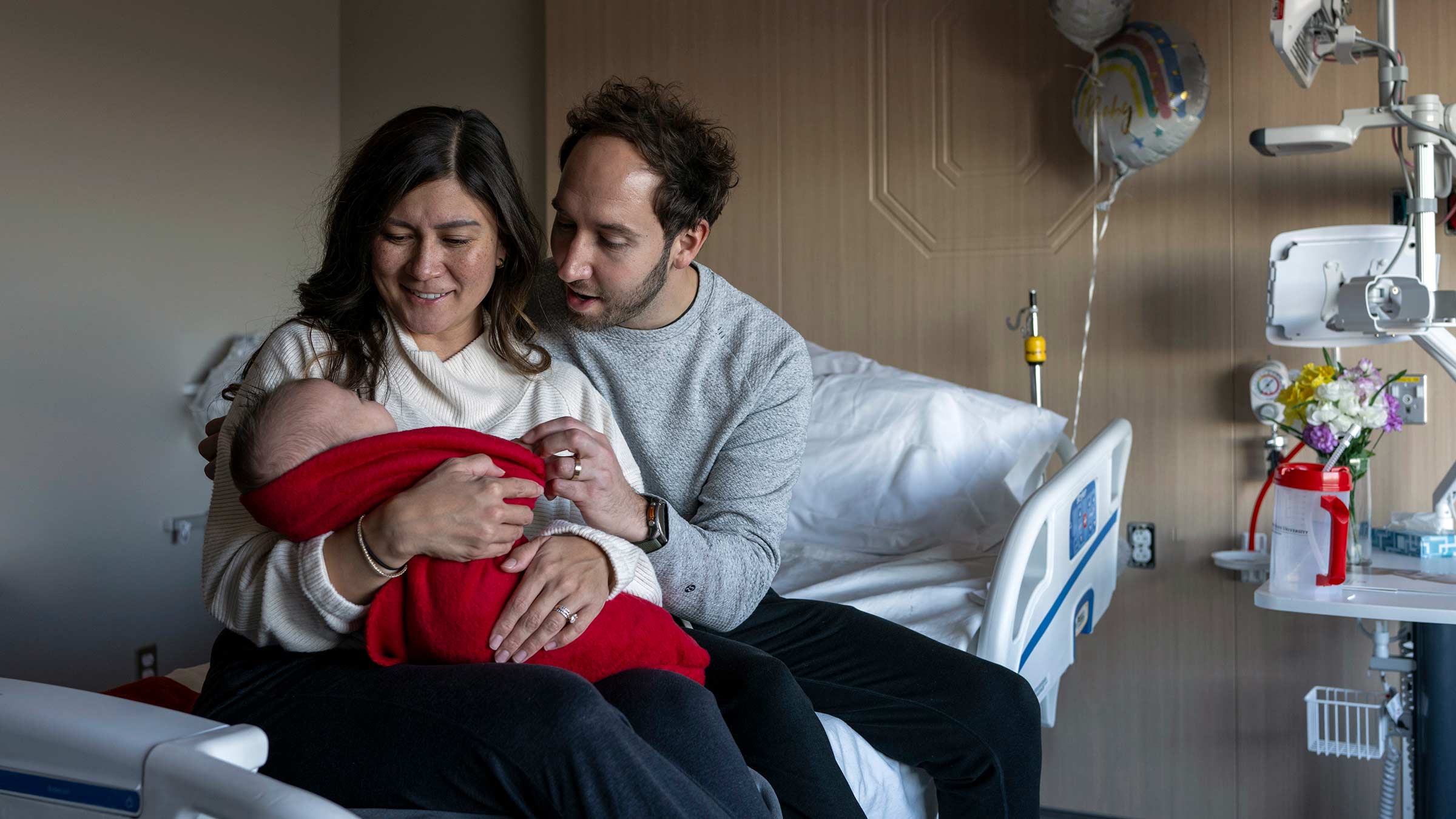 New parents holding their baby in one of the new private patient rooms