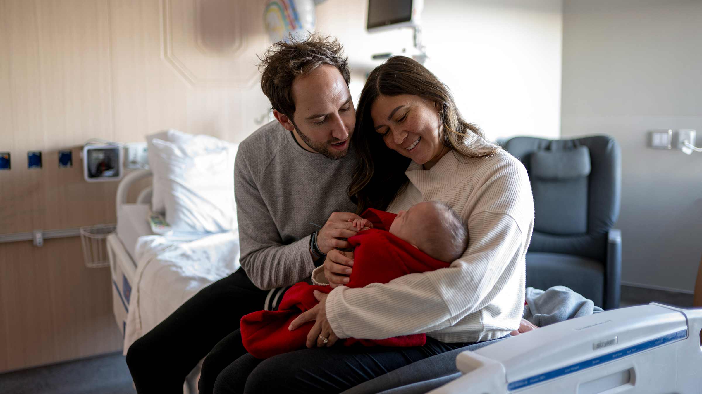 New parents holding their baby in one of the new private patient rooms