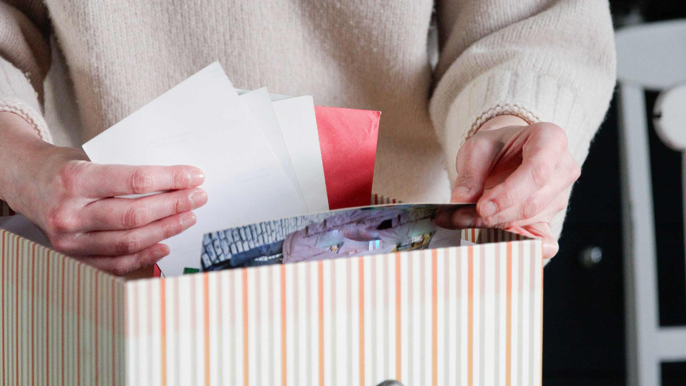 Person looking through a box of cards and photos