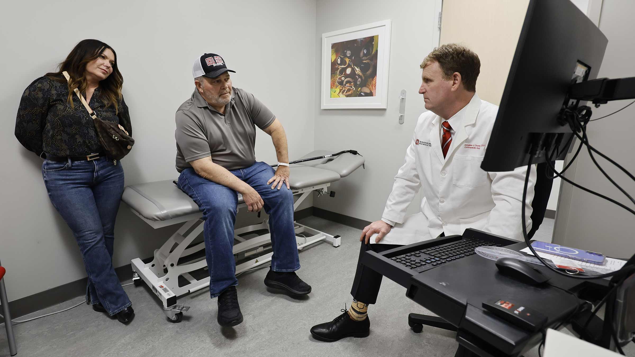 Patient and his wife meet with a doctor in a clinical setting