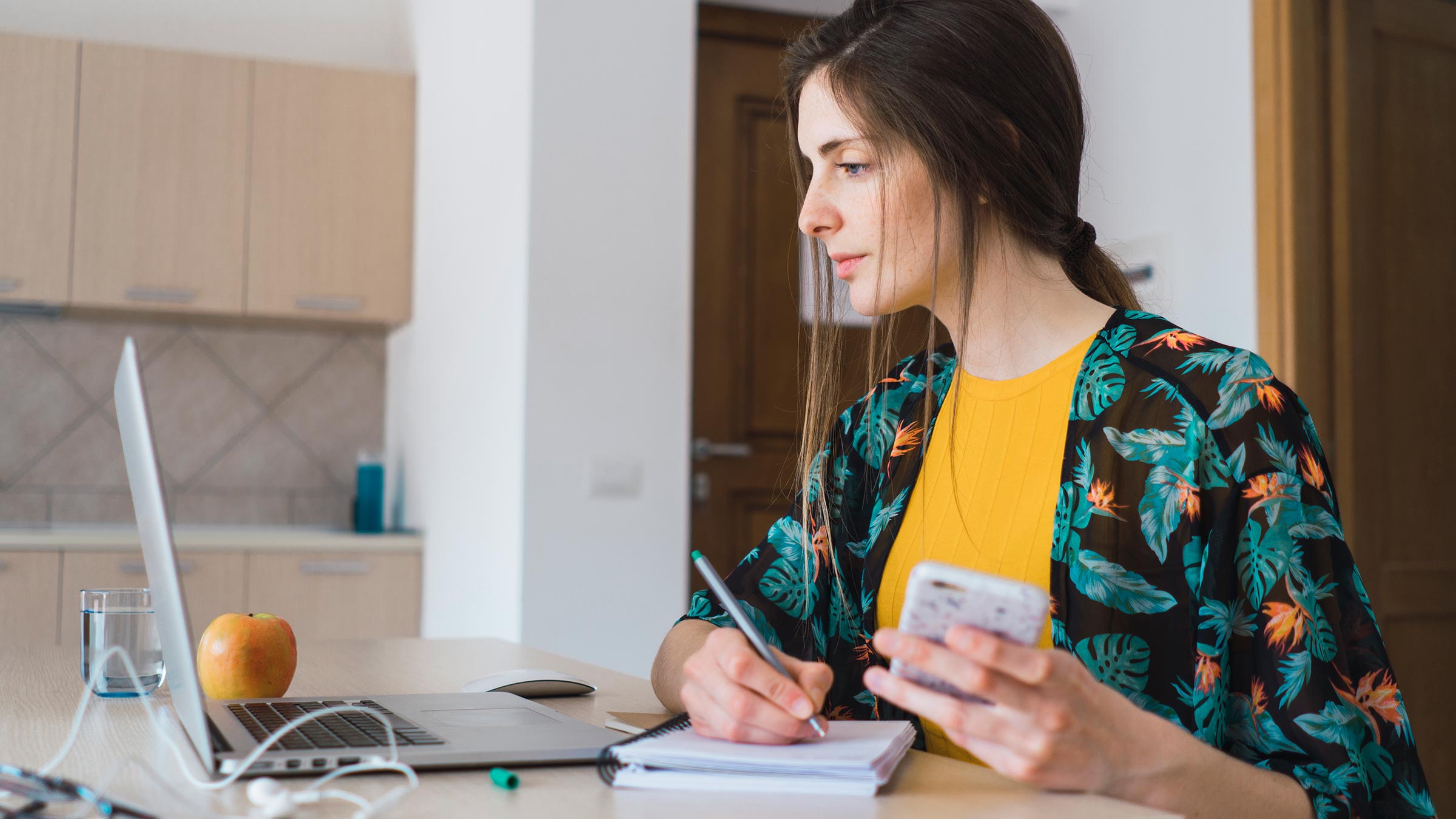 Woman using laptop and  taking notes on evidence-based healthcare practices