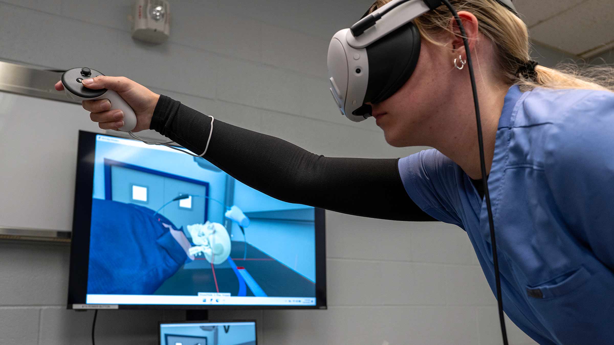 Student using virtual reality headset and tool to point