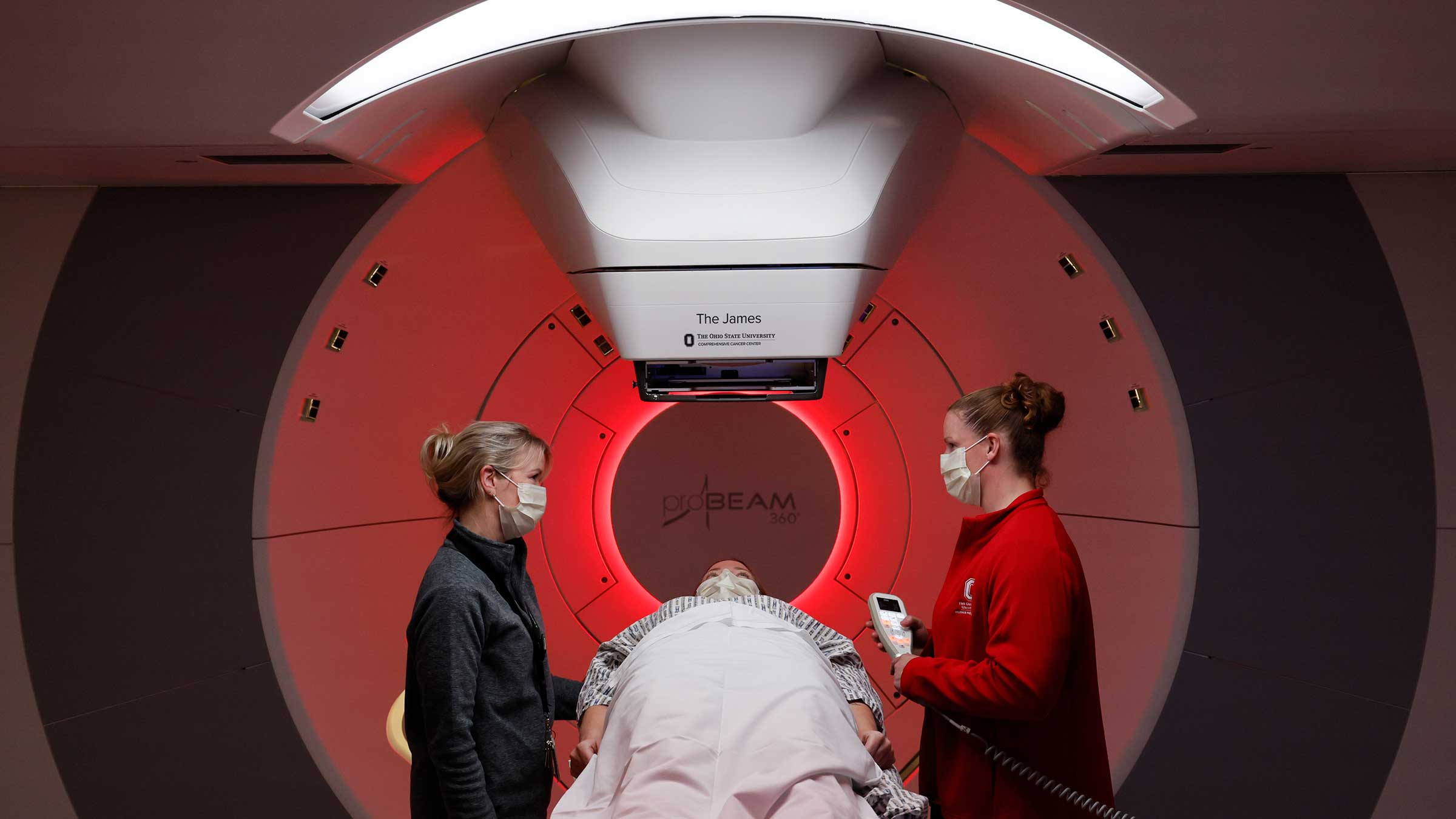 A nurse prepares a patient and their partner for proton radiation inside the proton therapy machine