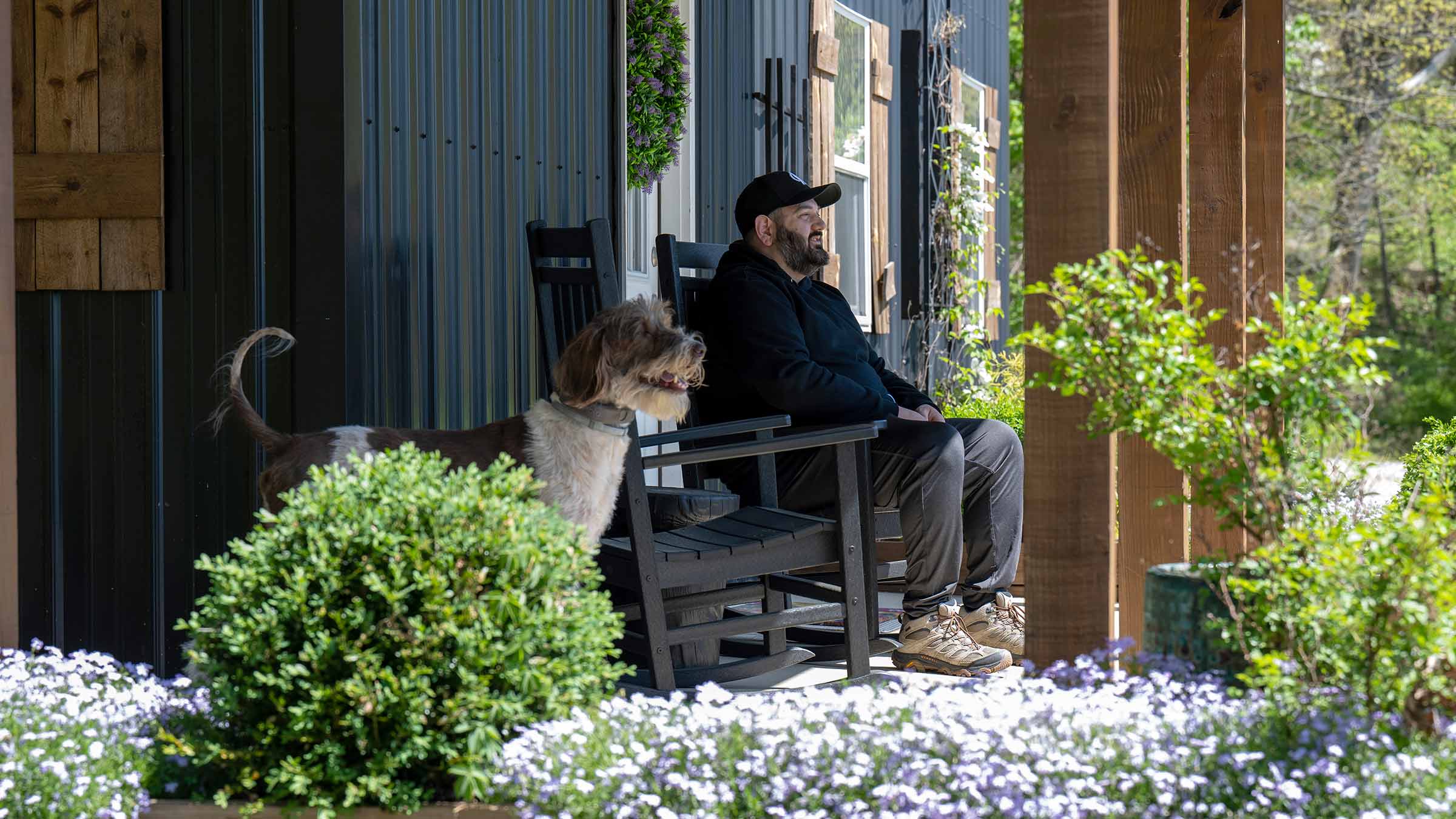 Patient, Alex Toomey, sitting outside on his front porch with his dog