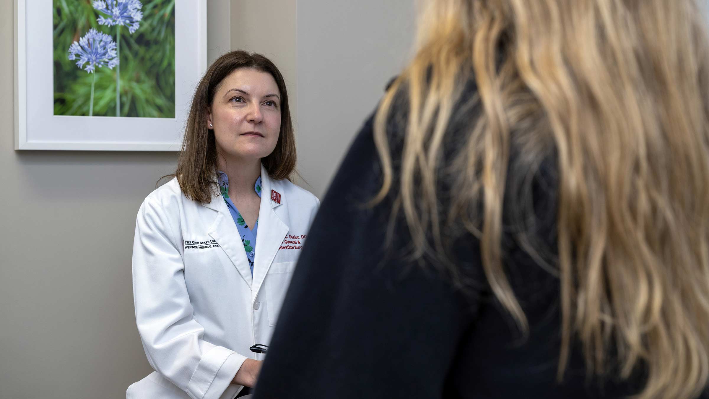 Colon and rectal surgeon, Alessandra Gasior, speaking with a patient in an exam room