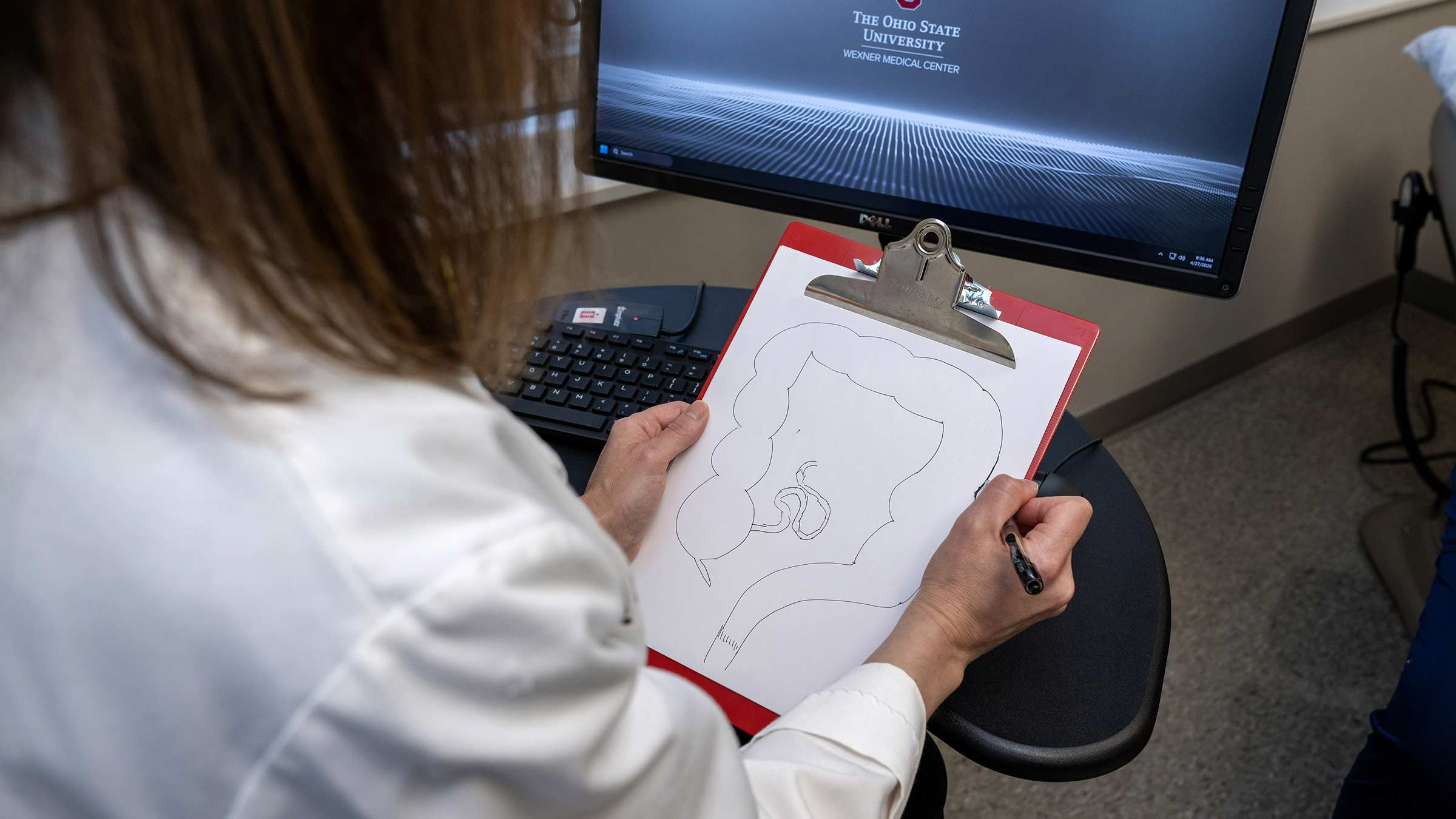 Colon and rectal surgeon, Alessandra Gasior sketching out a diagram of a large intestine on a sheet of paper