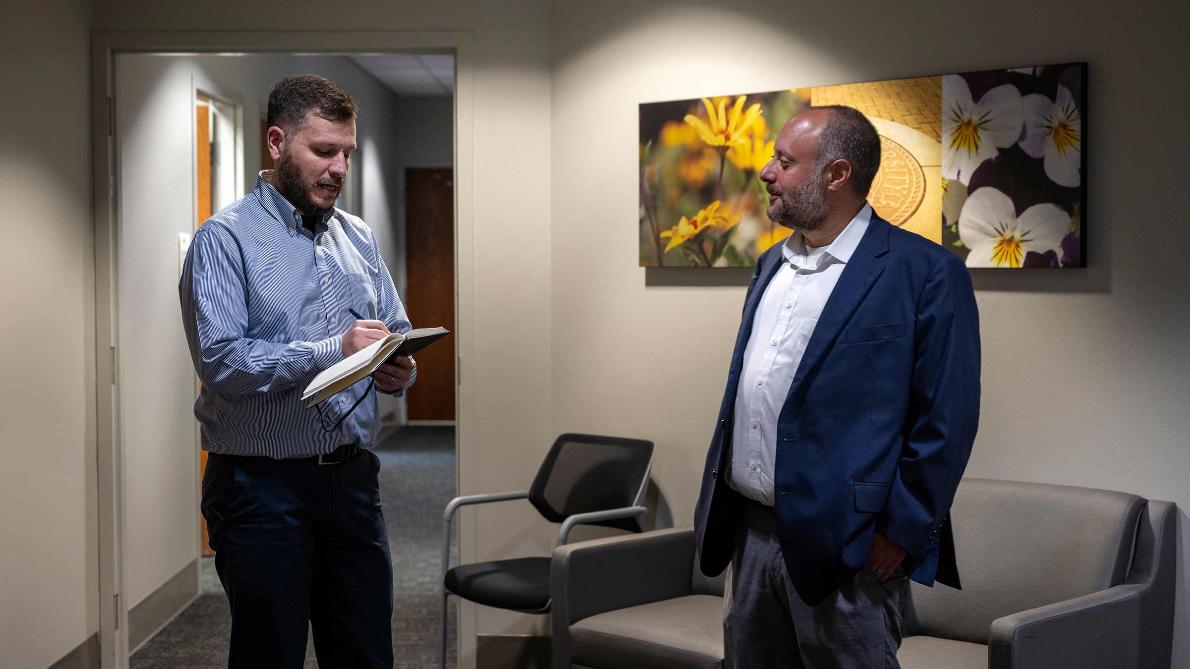 David Weiss, PhD, and Nick Breitborde talking in the hallway