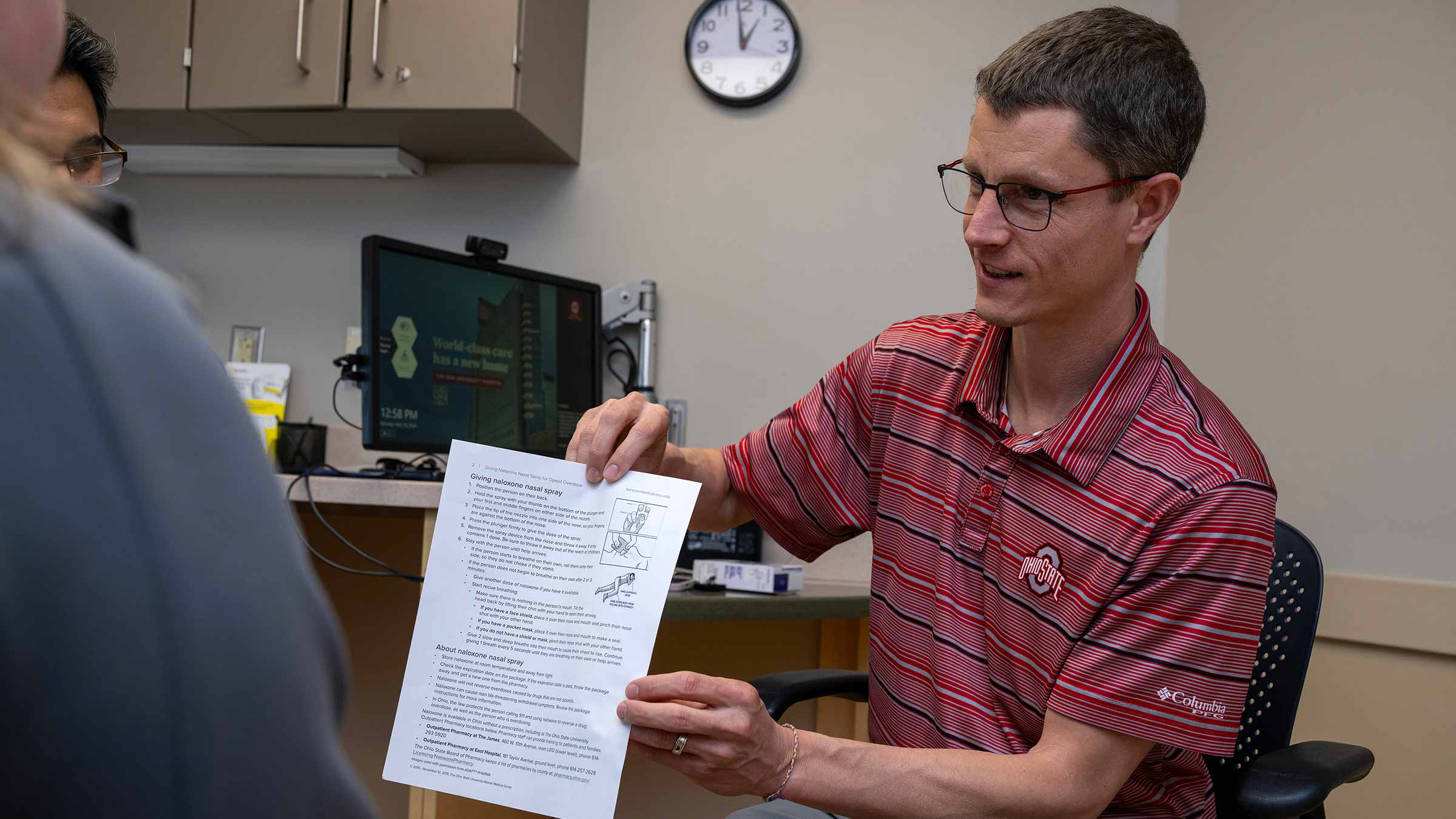 Justin Kullgren, PharmD, talking to a patient