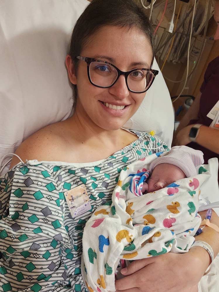 Breast cancer survivor, Caitlin Conner holding her newborn son