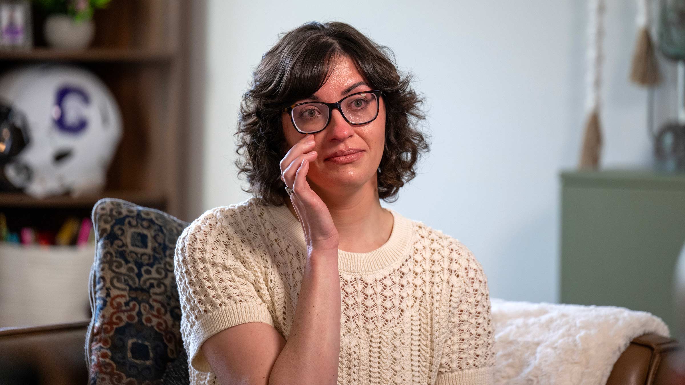 Breast cancer survivor, Caitlin Conner, wiping a tear