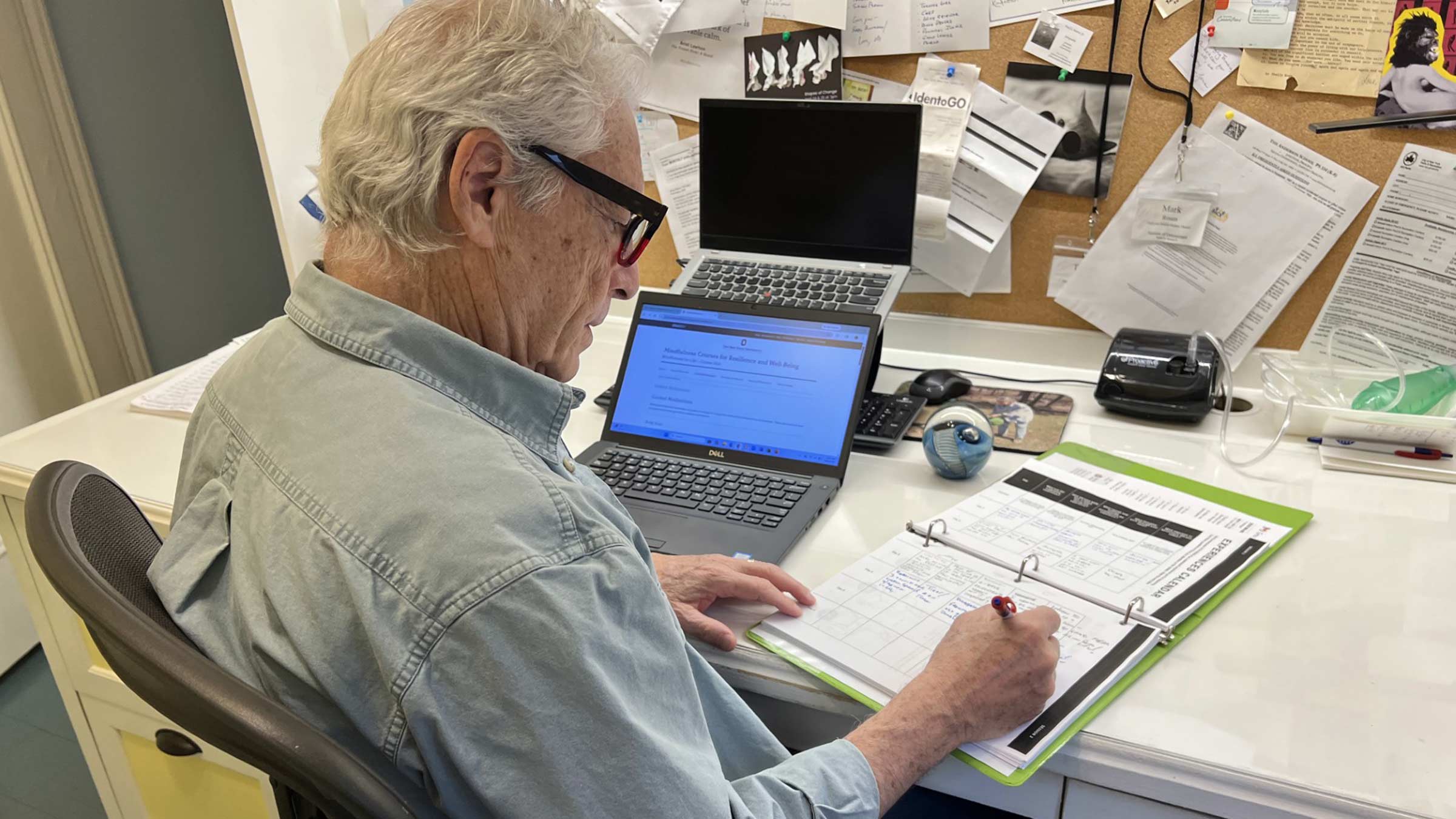 Mark Rosen sitting at a desk looking at a schedule