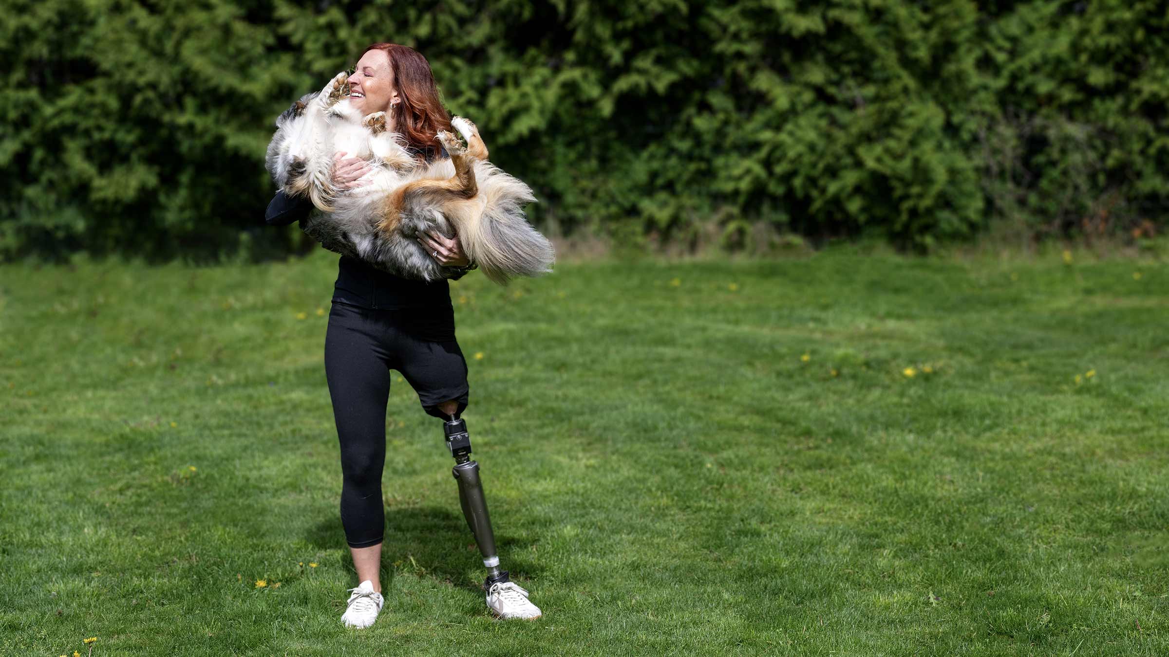 Stacey Finley standing outside holding her dog in her arms