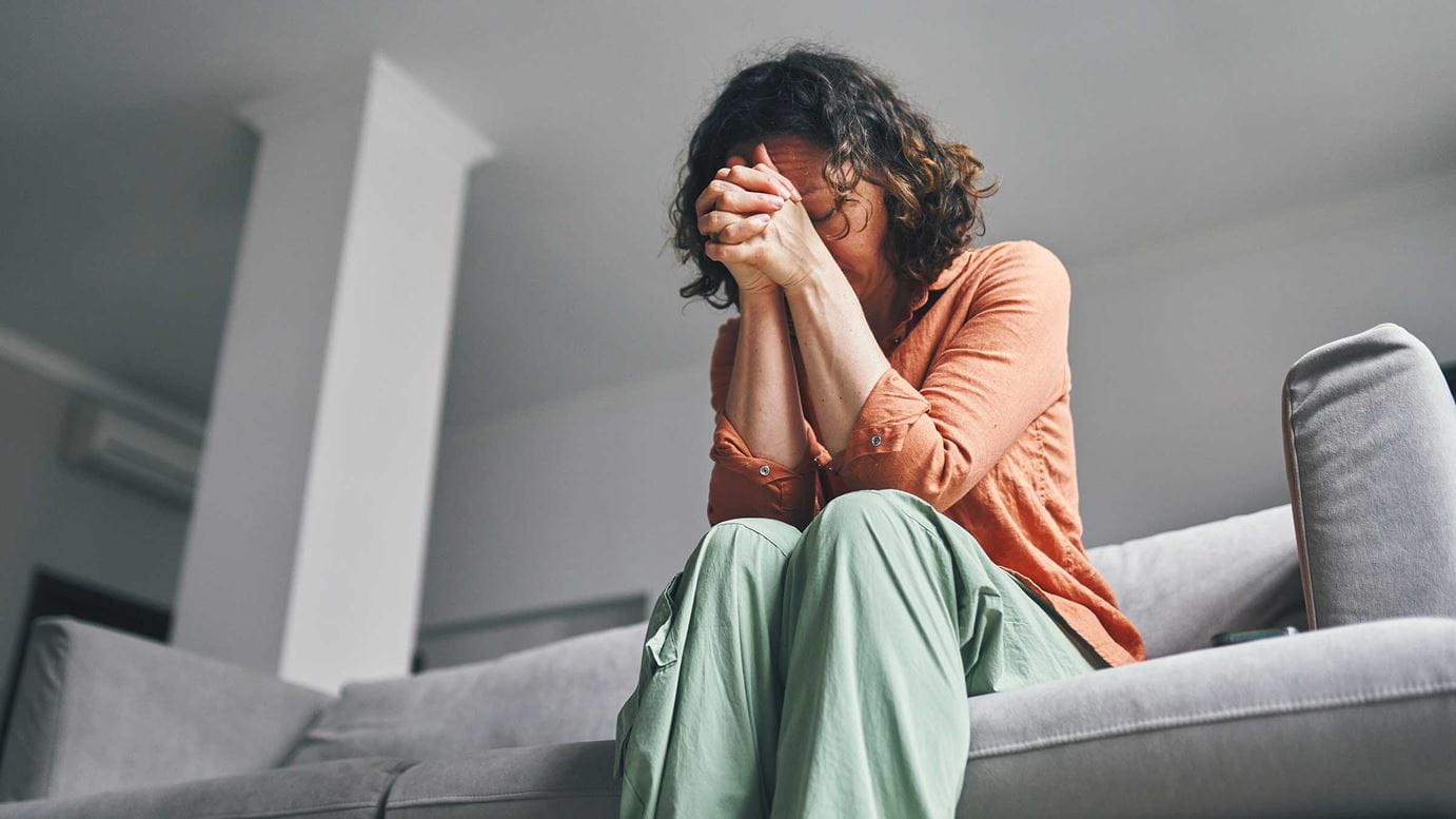 Woman in distress sitting on a couch