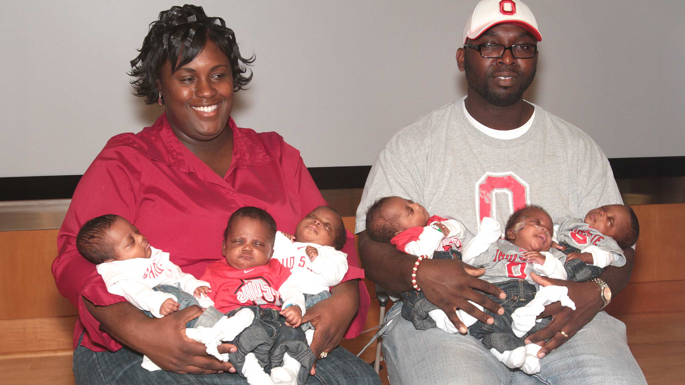 Mia and Rozonno McGhee pose with their newborn babies, three in each parent's arms