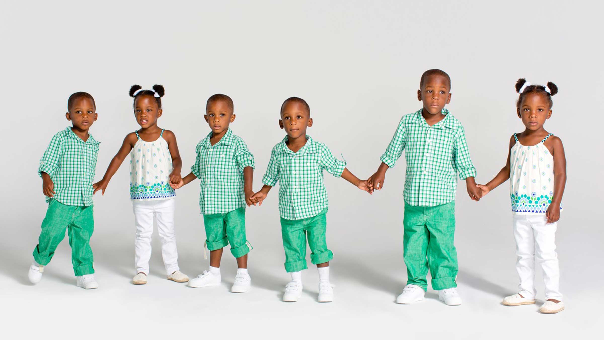 Sextuplets as toddlers, holding hands