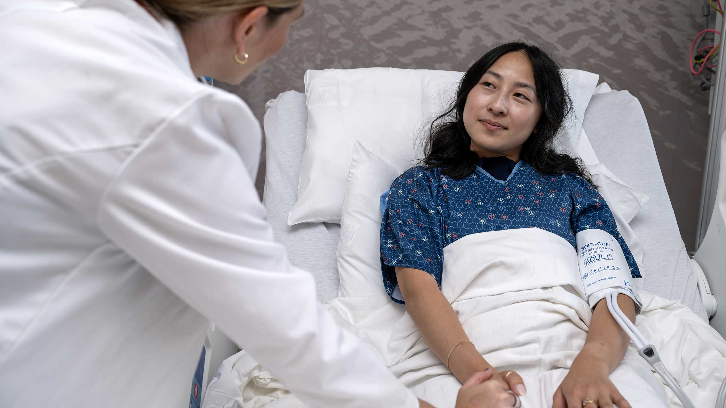 A doctor tending to a palliative care patient in a hospital bed