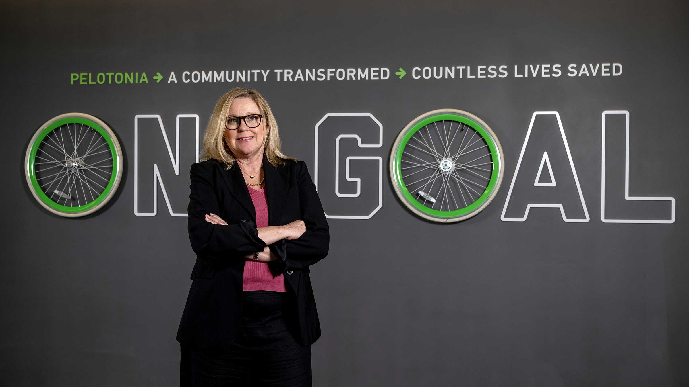 Dr. Chandler standing in front of the Pelotonia “One Goal” sign in the Pelotonia Research Center
