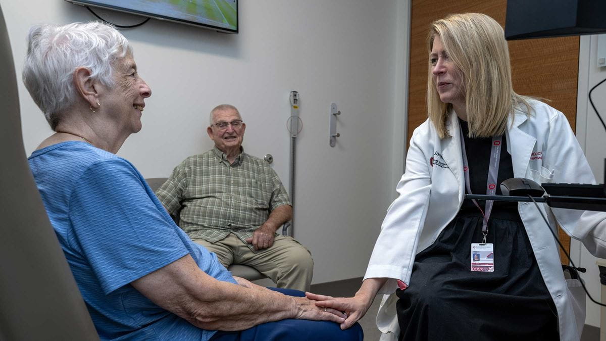 Dr. Alice Mims reaching out to hold her patient Judith Moyer’s hand