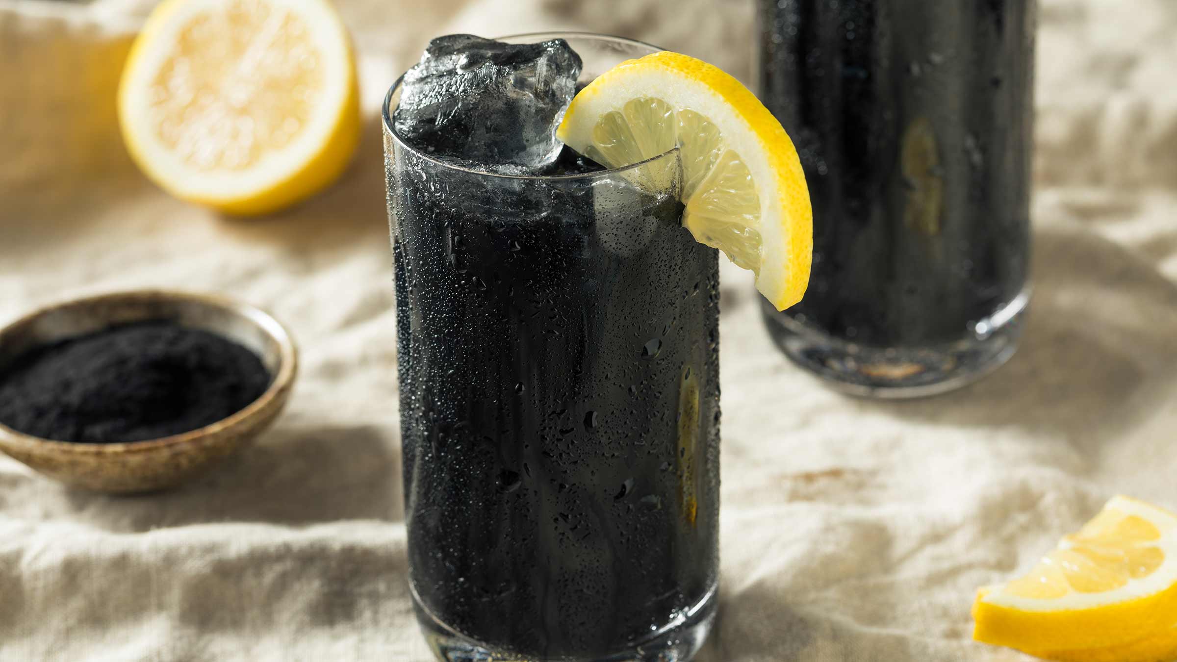 A close-up image of a black, activated charcoal lemonade drink