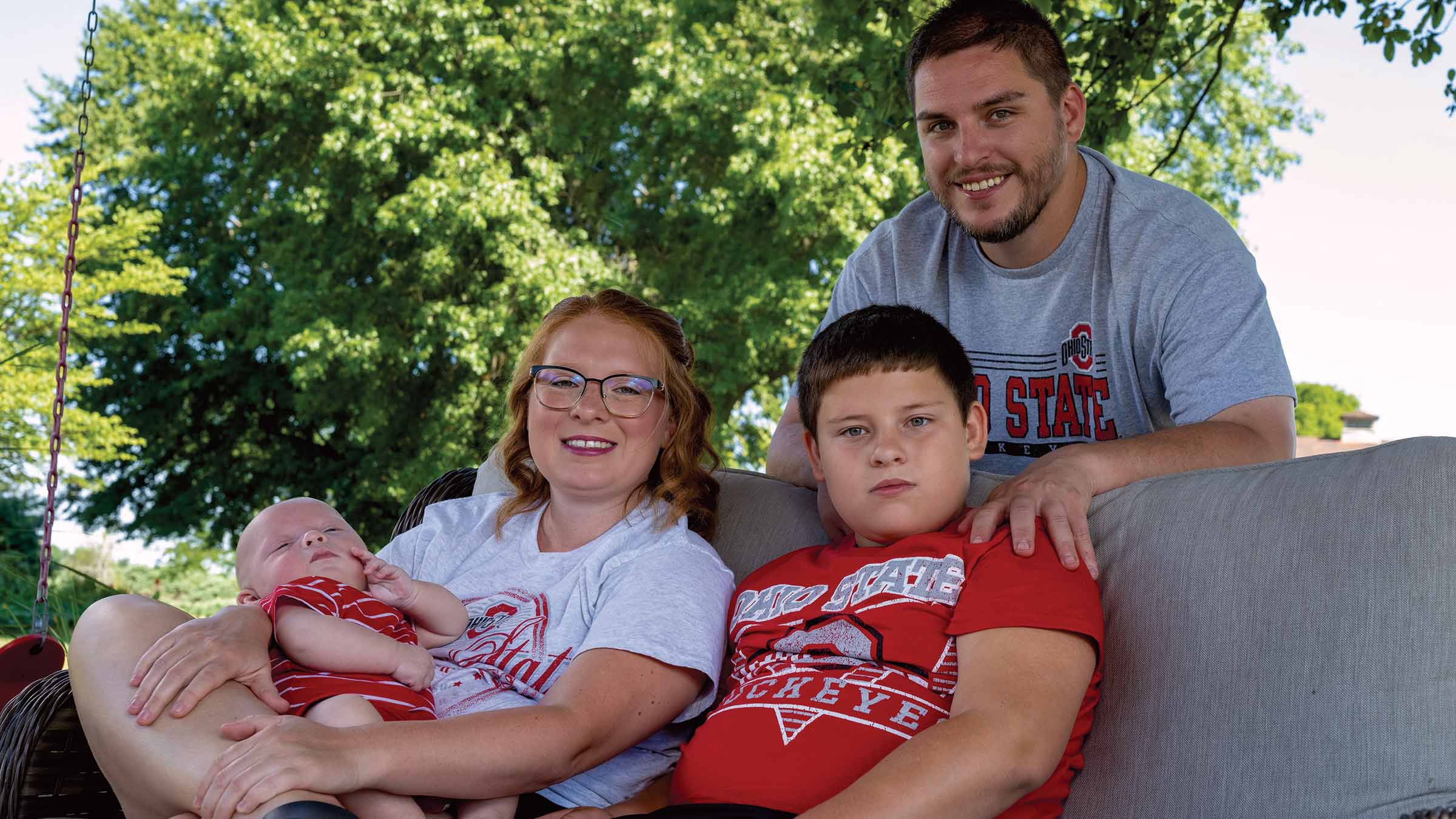 The McDaniel family sitting on a porch wearing Ohio State apparel