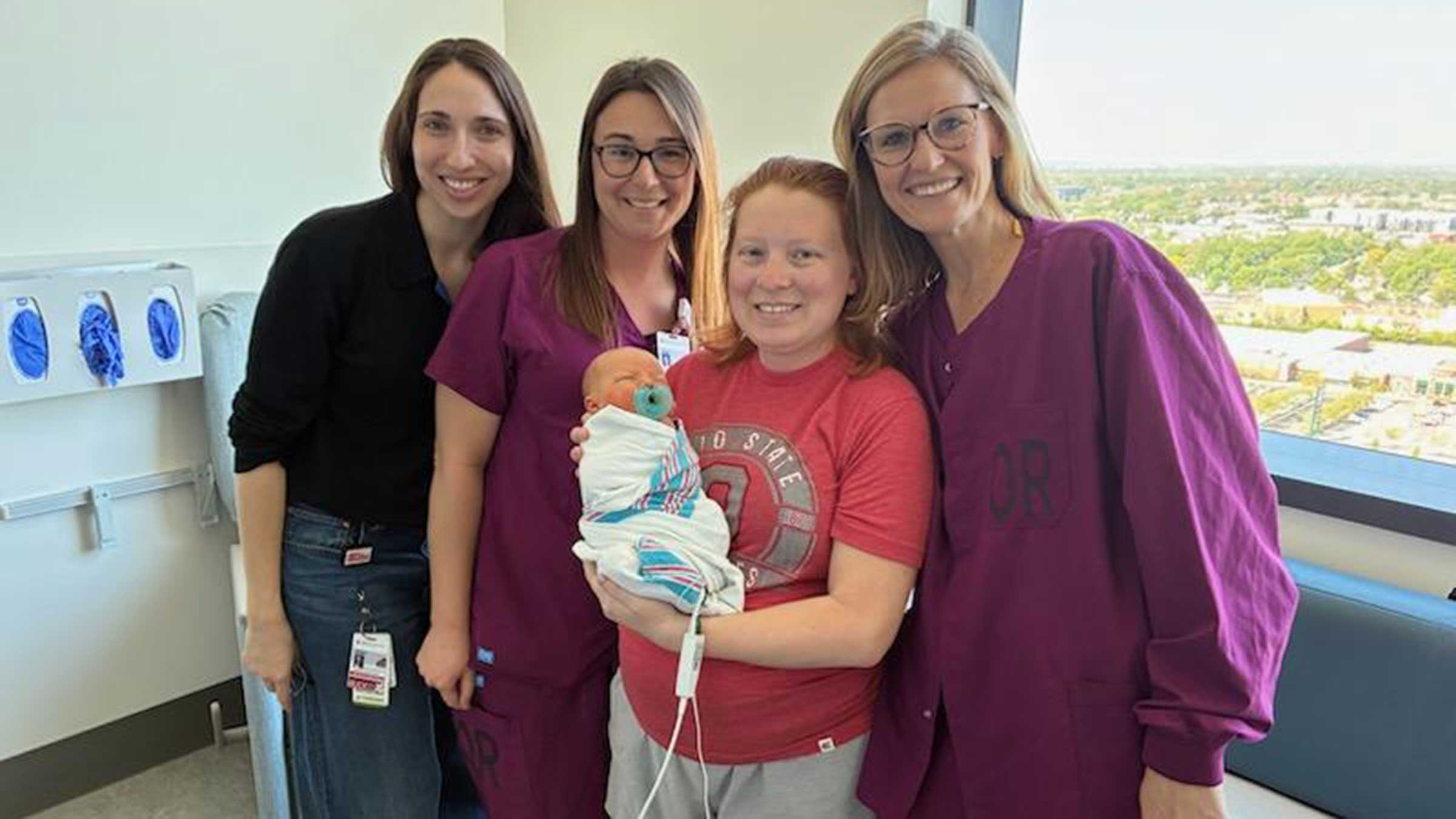 Ohio State staff posing with Tori McDaniel and newborn Isaiah