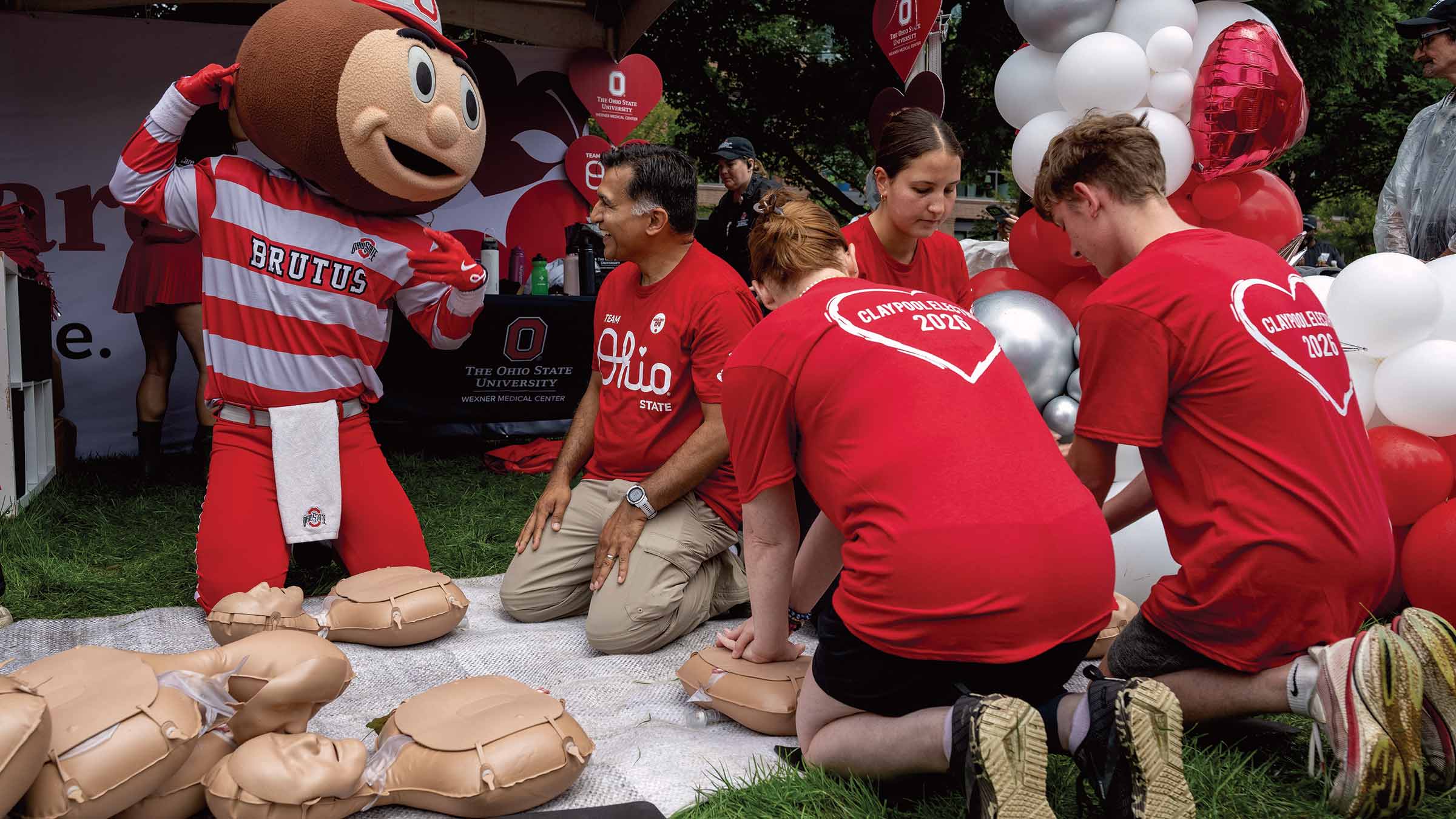 Dr. Ashish Panchal, with the help of Brutus, demonstrates how to perform CPR on dummies at the Ohio State heart walk