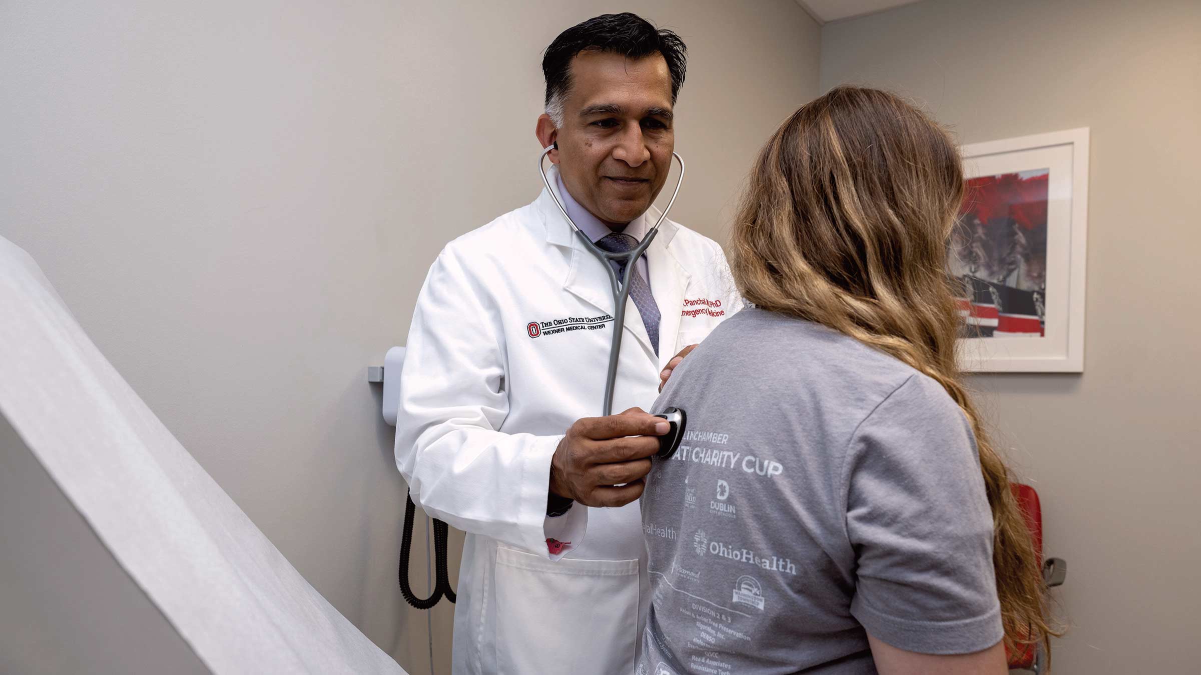 Dr. Ashish Panchal listens to a woman’s heart in a clinical setting